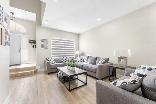 a living room with furniture and wooden floor