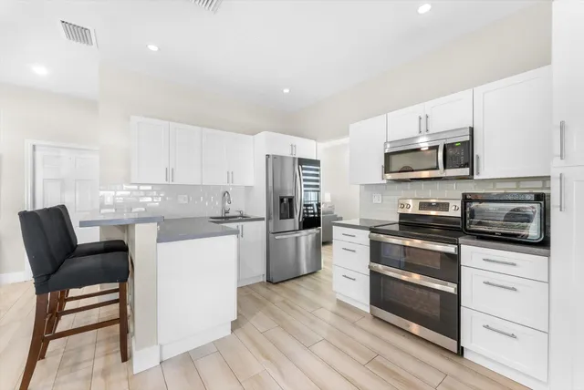 a kitchen with stainless steel appliances a stove top oven a sink and a chandelier