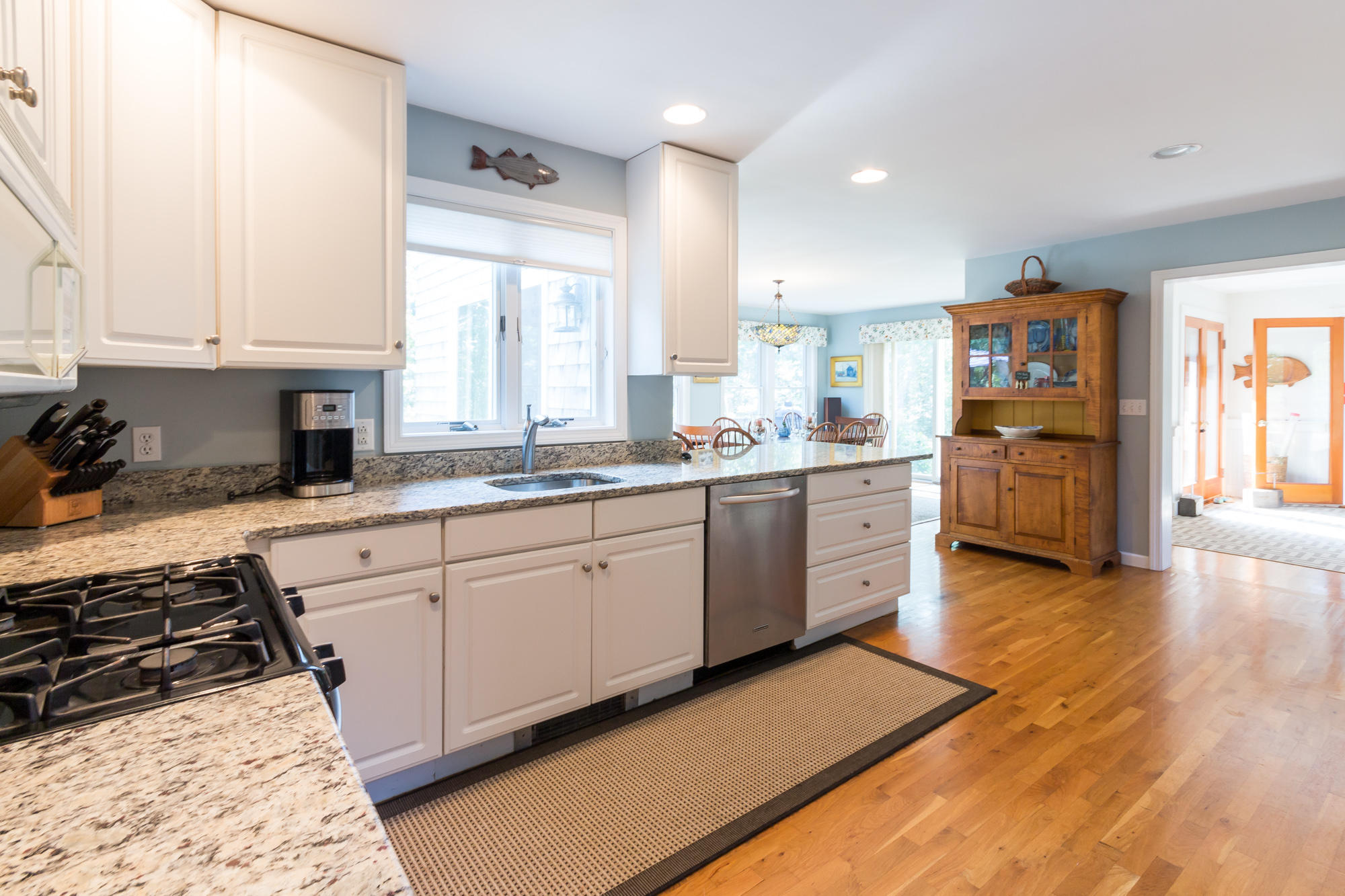 321 Chappaquiddick Road Edgartown, MA 02539 - Photo 5 of 35 a kitchen with stainless steel appliances granite countertop a stove top oven a sink dishwasher and white cabinets with wooden floor