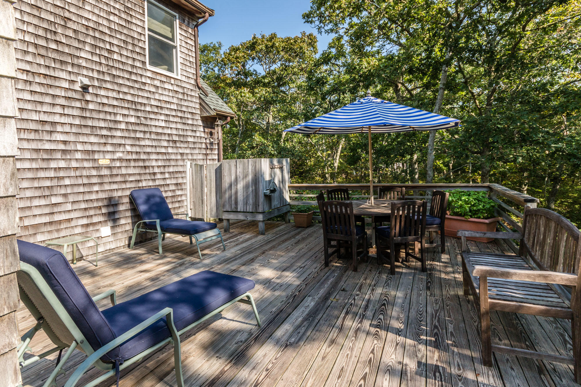 321 Chappaquiddick Road Edgartown, MA 02539 - Photo 8 of 35 a backyard view of a house with table and chairs