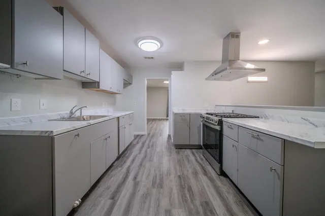 a kitchen with a sink stove and cabinets