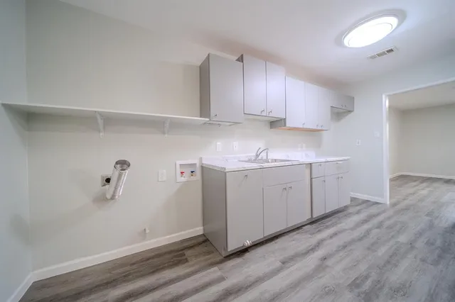 a kitchen with sink cabinets and wooden floor