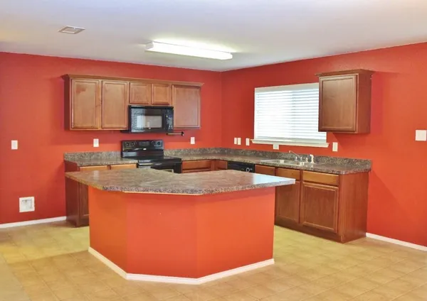 a kitchen with stainless steel appliances granite countertop a stove a sink dishwasher and a refrigerator