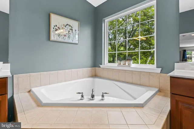 a white bath tub sitting in a bathroom next to a window