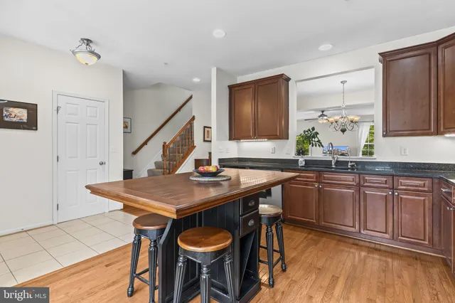 a kitchen with stainless steel appliances granite countertop a sink a stove a table and chairs