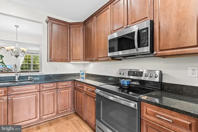 a kitchen with stainless steel appliances granite countertop a sink a stove a microwave oven and cabinets
