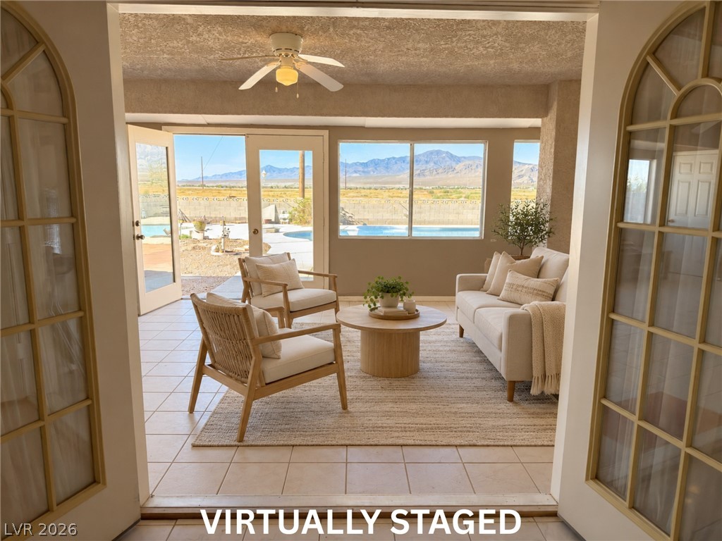5470 Grain Mill Road Pahrump, NV 89061 - Photo 49 of 80 VIRTUALLY STAGED. Double doors leading from the family room/Kitchen out to the enclosed patio. Sunlight streams through expansive windows, framing mountain vistas beyond the tiled sunroom floor.