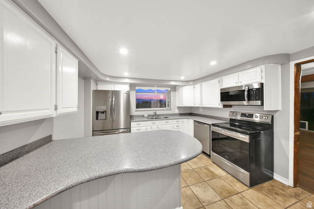 374 West Lakeview Road Lindon, UT 84042 - Photo 16 of 44 Kitchen featuring white cabinetry, speckled countertops, and stainless steel appliances