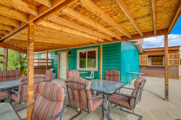 a view of a patio with a table and chairs under an umbrella