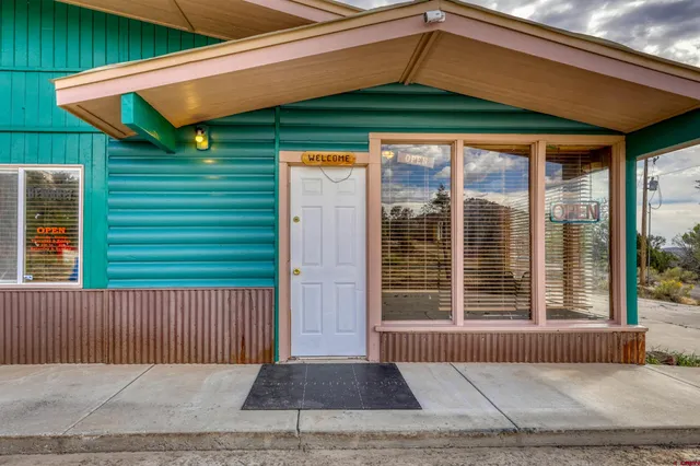 a view of a house with a floor to ceiling window and wooden fence