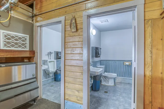 a bathroom with a toilet a sink and mirror