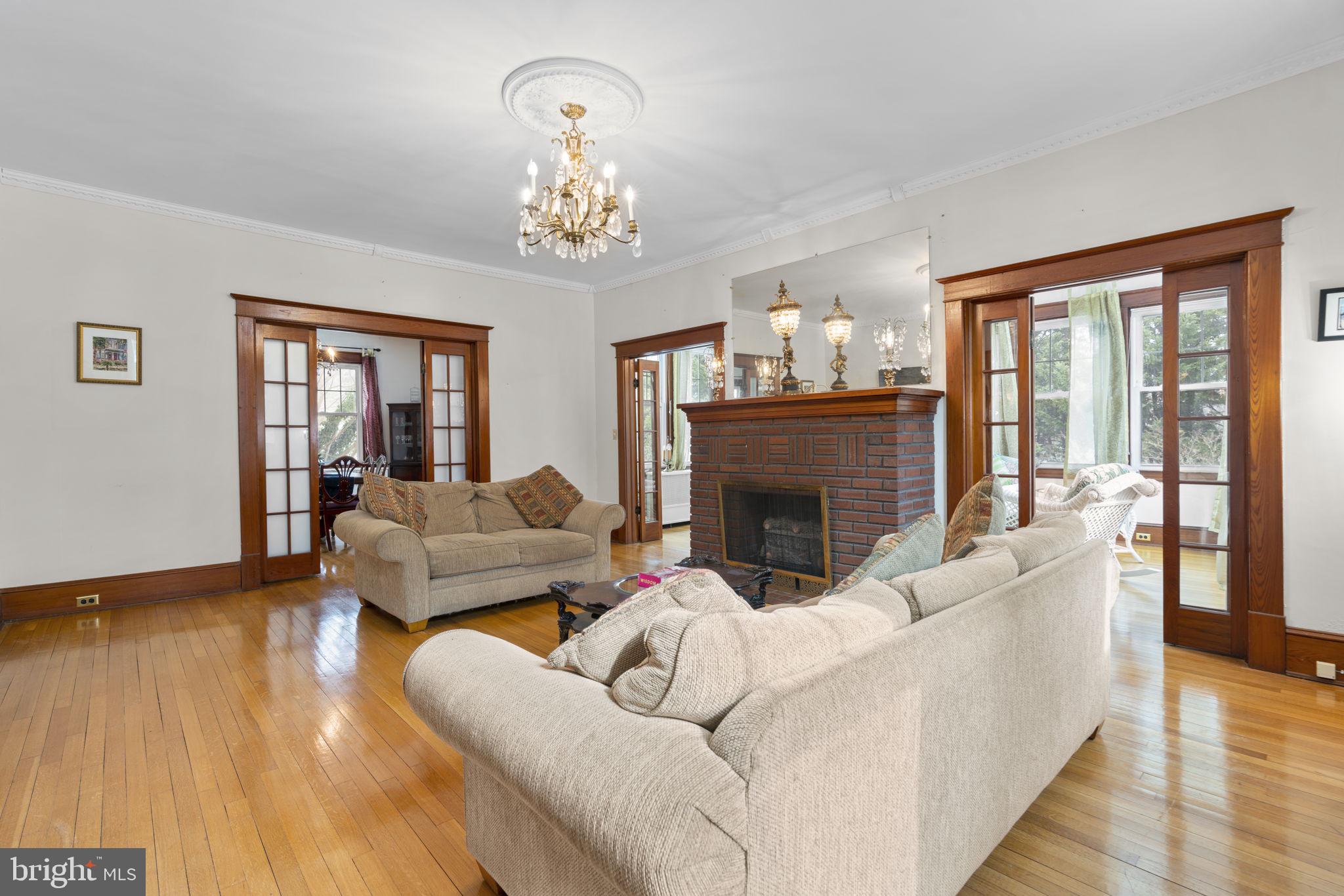 6100 Frederick Road Catonsville, MD 21228 - Photo 6 of 61 a living room with furniture a chandelier and a fireplace