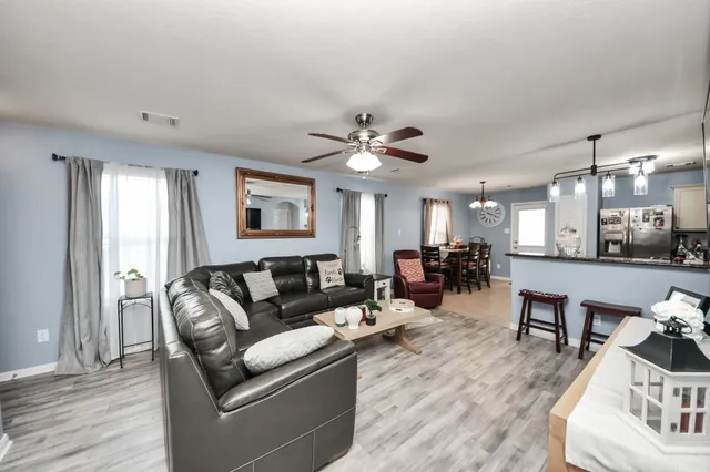 a living room with furniture and a wooden floor