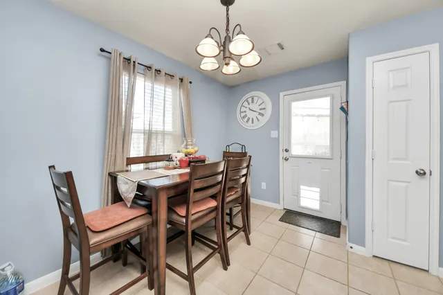 a dining room with wooden floor a chandelier a wooden table and chairs