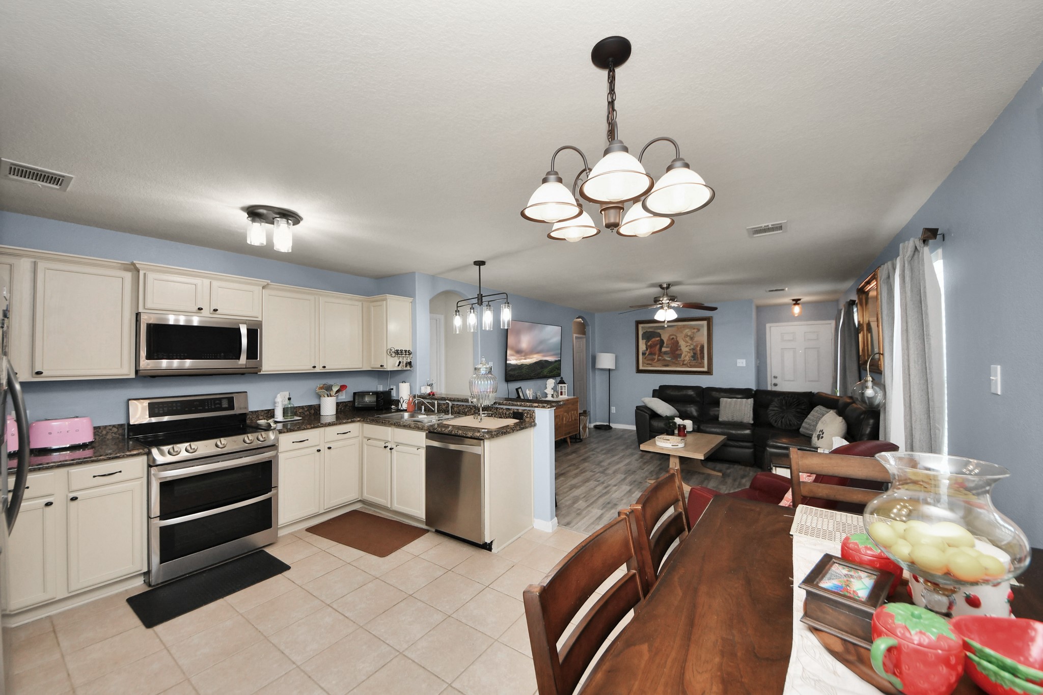 28961 San Bernard River Loop Spring, TX 77386 - Photo 16 of 36 a kitchen with stainless steel appliances granite countertop a stove top oven a sink a stove a dining table and chairs with wooden floor