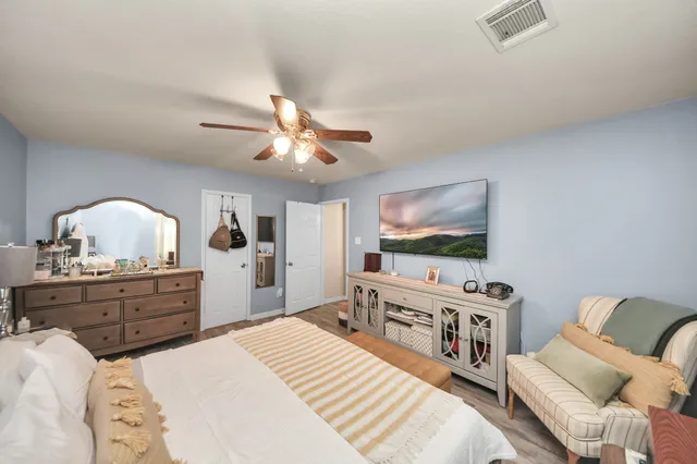 a bedroom with furniture and a flat screen tv