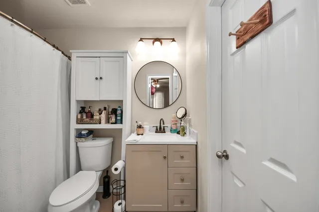 a bathroom with a toilet sink and mirror
