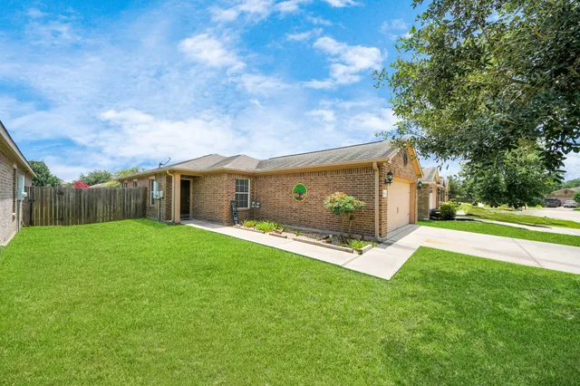 a view of a house with backyard and a tree