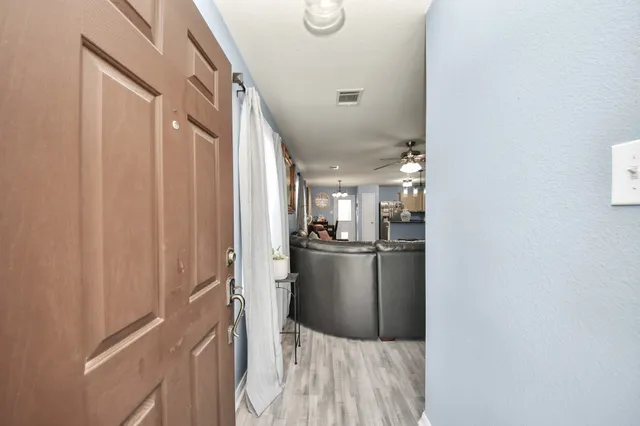 a kitchen with kitchen island wooden floor and refrigerator