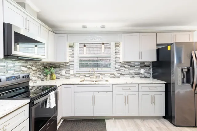 a kitchen with white cabinets and white appliances