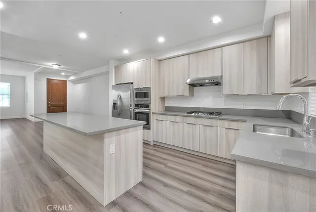 a kitchen with stainless steel appliances granite countertop a sink stove and cabinets
