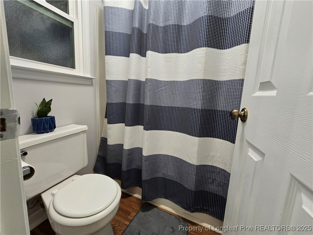 944 Flintwood Road Fayetteville, NC 28314 - Photo 22 of 24 a white toilet sitting next to a bathroom sink and a mirror
