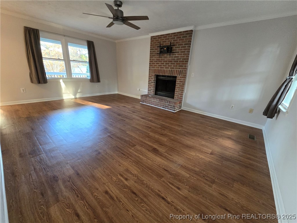 944 Flintwood Road Fayetteville, NC 28314 - Photo 3 of 24 an empty room with wooden floor fireplace and windows