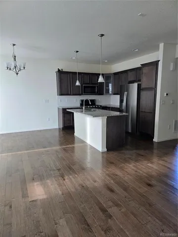 a kitchen with stainless steel appliances granite countertop a sink a stove and a refrigerator