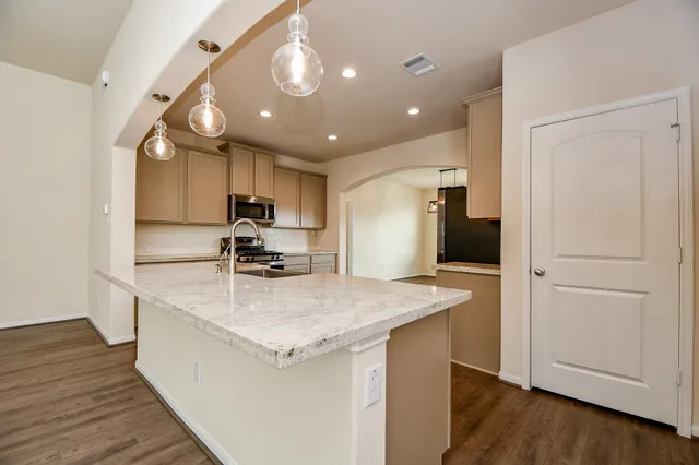 a kitchen with a refrigerator and a stove top oven