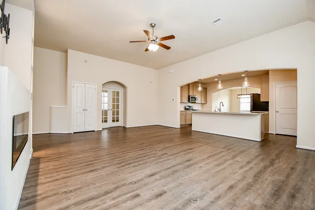 a large kitchen with stainless steel appliances a large counter top a stove a sink and a refrigerator