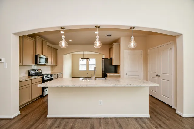 a kitchen with a sink appliances and cabinets