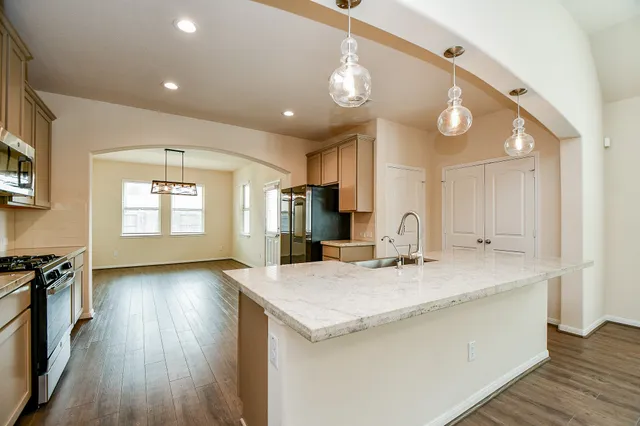 a large white kitchen with wooden floors and white cabinets