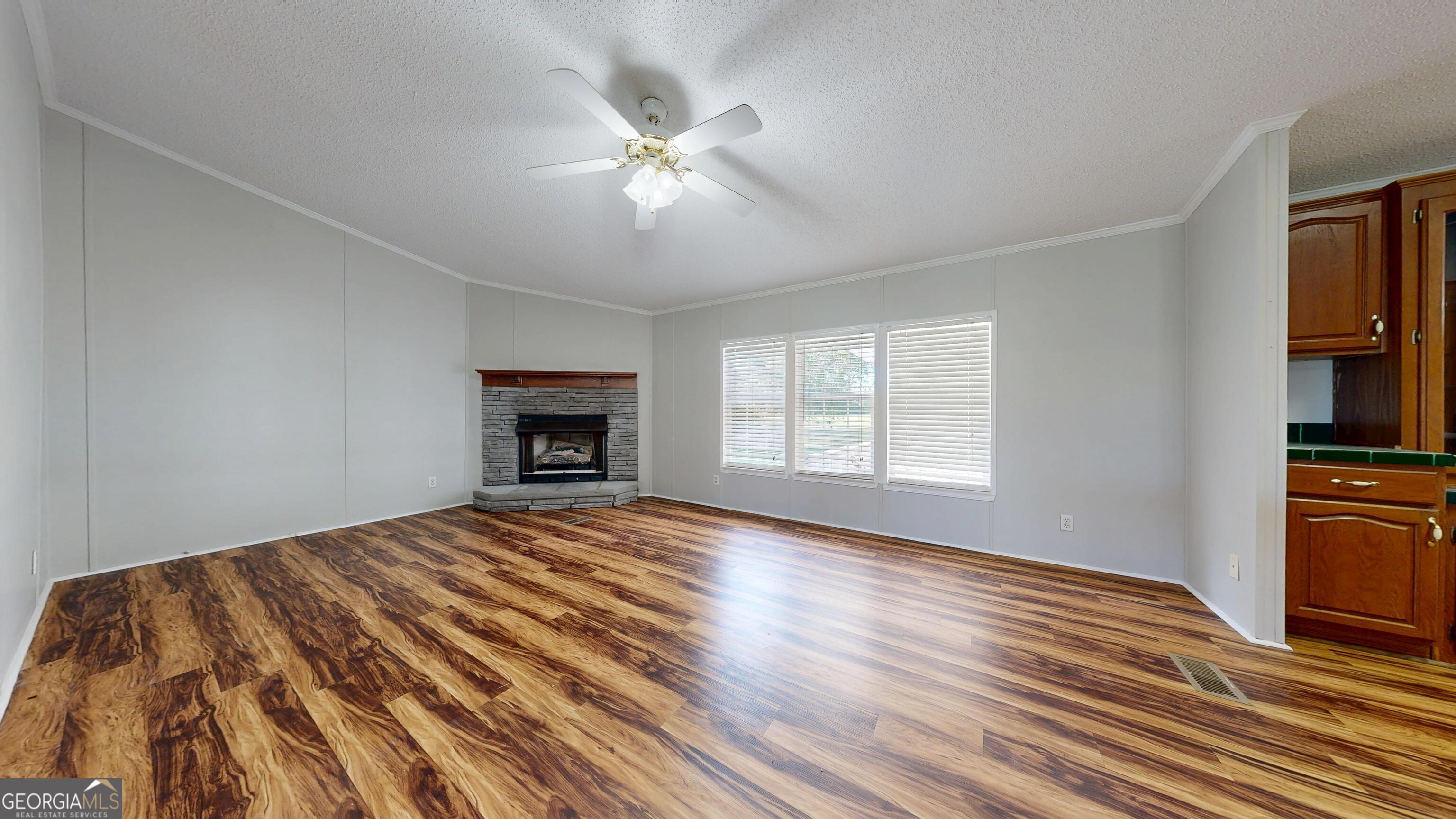 6498 Central Avenue Waycross, GA 31503 - Photo 4 of 20 a view of an empty room with wooden floor and a window