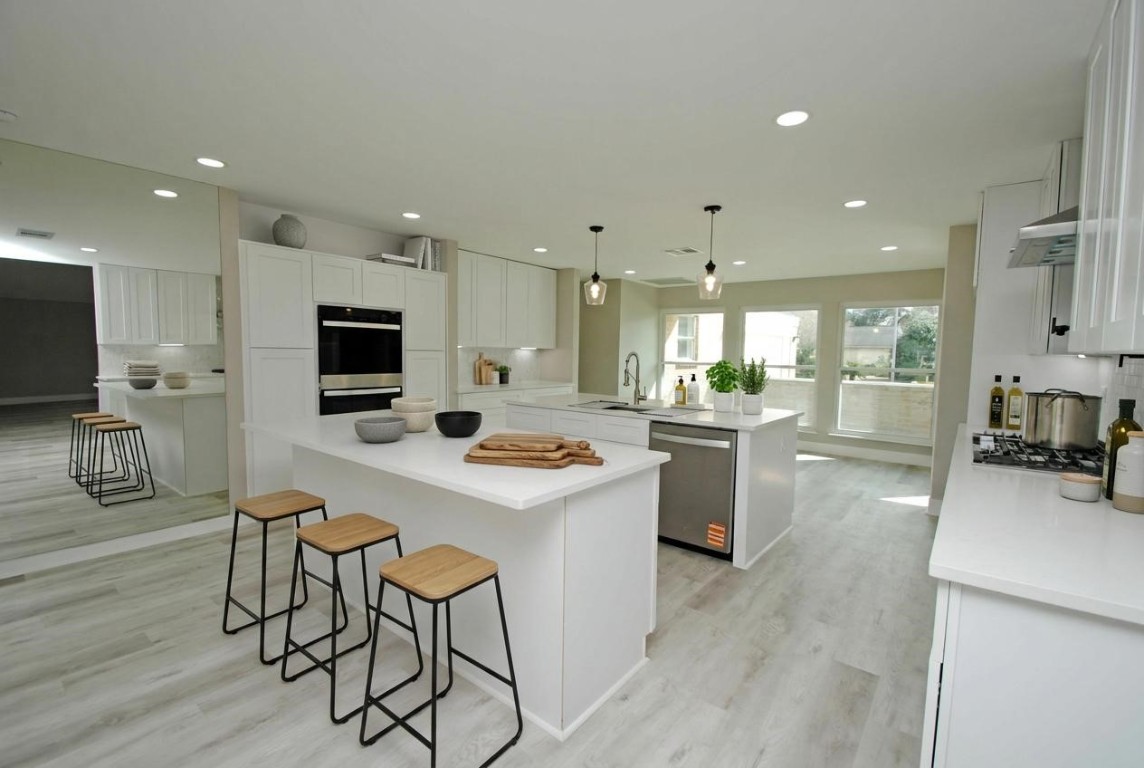 3322 Robinson Road Missouri City, TX 77459 - Photo 6 of 27 a kitchen with a sink a stove a refrigerator and white cabinets with wooden floor