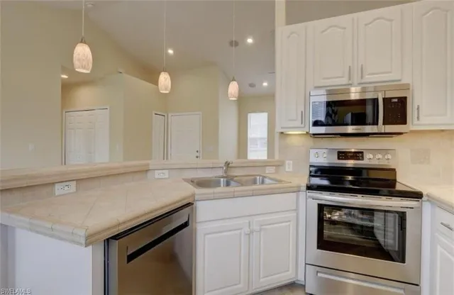 a kitchen with a sink stove and microwave