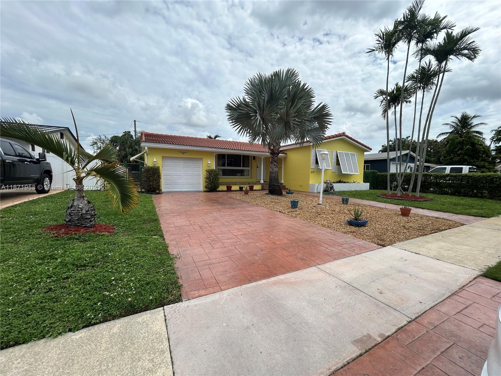 3219 Wilson Street Hollywood, FL 33021 - Photo 1 of 15 a front view of a house with a yard and potted plants