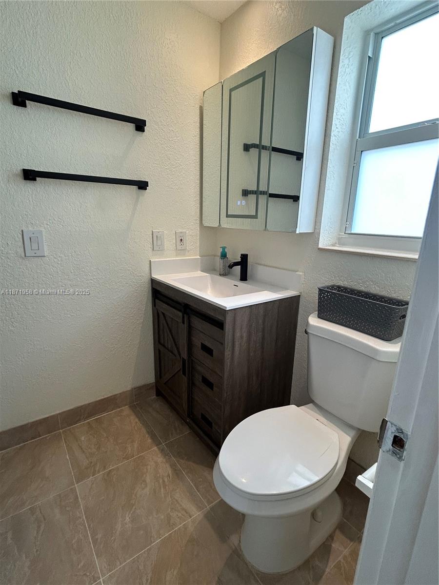 3219 Wilson Street Hollywood, FL 33021 - Photo 11 of 15 a bathroom with a toilet a sink and mirror