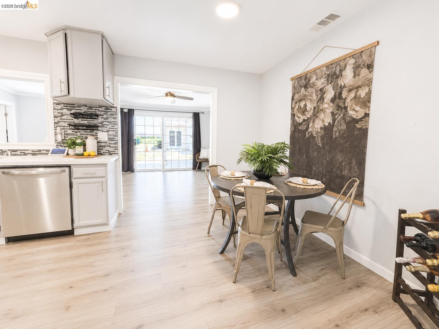 2191 East Cypress Road Oakley, CA 94561 - Photo 7 of 48 Open-concept living space featuring wood-finish flooring throughout, a modern kitchen with stainless steel appliances, light-toned cabinetry, and a mosaic tile backsplash, and a dining area with recessed lighting