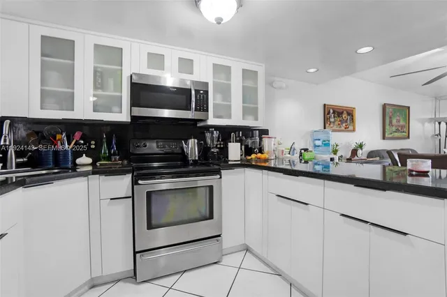 a kitchen with stainless steel appliances granite countertop a stove a sink and a microwave