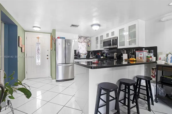 a kitchen with stainless steel appliances granite countertop a refrigerator and a stove top oven