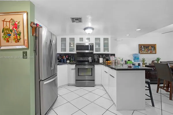 a kitchen with stainless steel appliances a refrigerator and a stove top oven