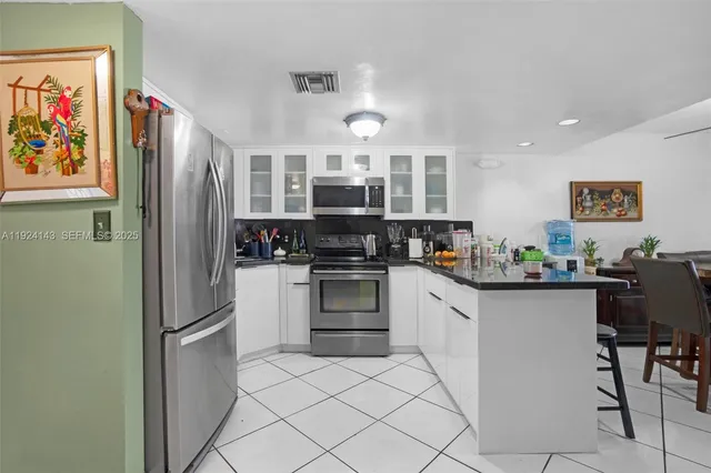 a kitchen with stainless steel appliances a refrigerator and a stove top oven
