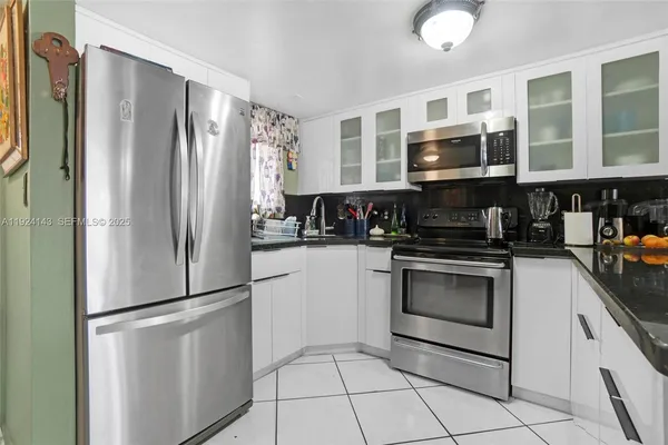 a kitchen with stainless steel appliances granite countertop a refrigerator a stove a microwave and cabinets