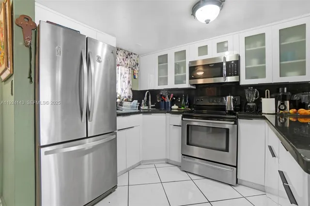 a kitchen with stainless steel appliances granite countertop a refrigerator a stove a microwave and cabinets