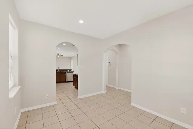 an empty room with a window and a ceiling fan