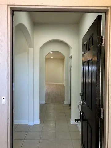 a view of a hallway with entryway and a livingroom view