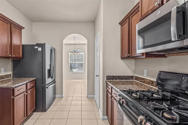 a kitchen with stainless steel appliances granite countertop a stove a refrigerator and a microwave