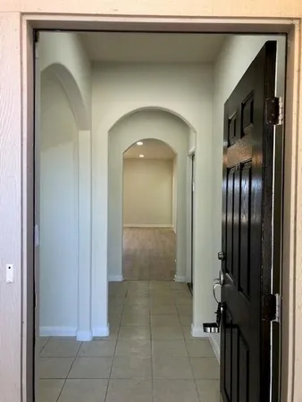 a view of a hallway with entryway and a livingroom view