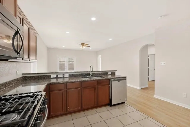 a kitchen with stainless steel appliances granite countertop a sink stove and refrigerator