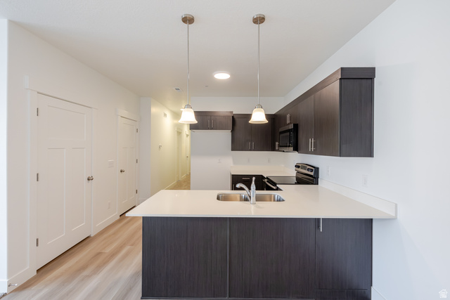 675 West 4500th South, Unit P201 Mapleton, UT 84664 - Photo 14 of 16 Modern kitchen featuring dark wood-finish cabinetry, light countertops, and a double basin stainless steel sink